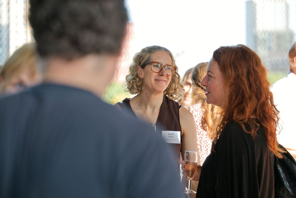 A group of Maykn launch attendees chatting on arrival, holding drinks.