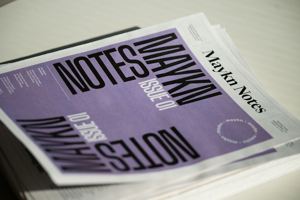 A print newspaper, Maykn Notes, arranged on a table at the Maykn launch event.